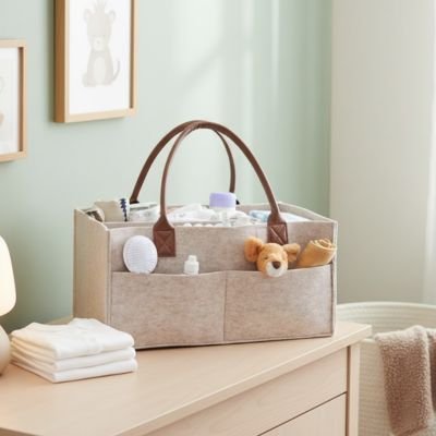 Panier de rangement bébé en tissu avec anses, posé sur une commode