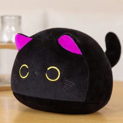 Peluche chat noir au tissu doux, posée dans une chambre enfant