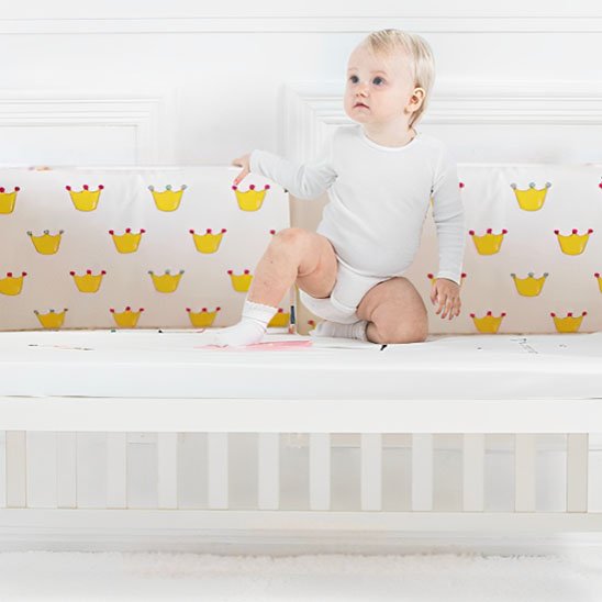 Tour de lit bébé en tissu doux installée dans un lit bébé