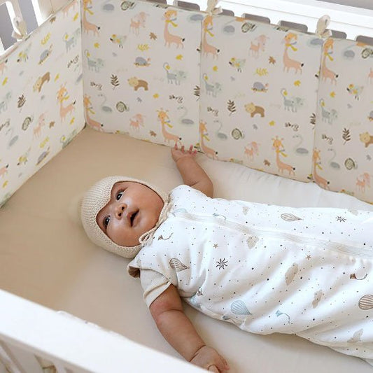 Tour de lit bébé en tissu doux installée dans un lit bébé