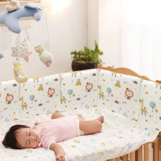 Tour de lit bébé posée autour du lit à barreaux