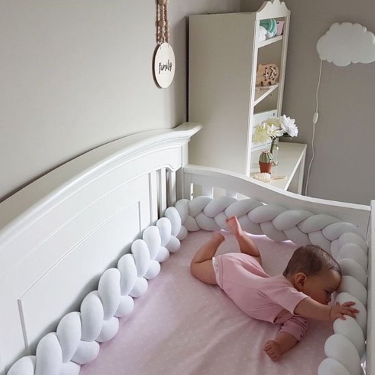 Tresse de lit en tissu doux installée dans un lit bébé